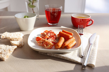 Plate with fried carrot and tomatoes on table served for lunch