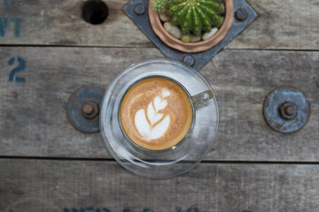 Top view latte art coffee on wooden table.