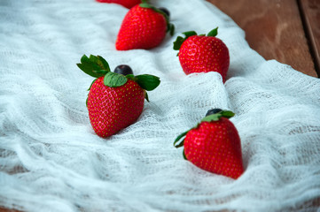 Fresh strawberries on a white napkin on a wooden background