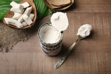 Coconut cream in opened tin on wooden table