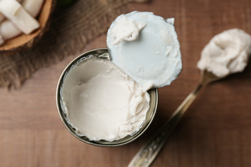 Fototapeta na wymiar Coconut cream in opened tin on wooden table