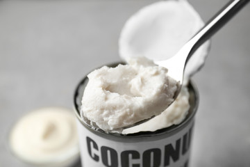 Coconut cream in spoon on grey background
