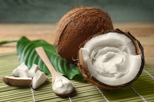 Coconut cream in nut on wooden background