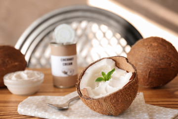 Fototapeta na wymiar Coconut cream in nut on wooden table