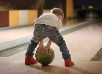 Naklejka premium Cute child with ball in bowling club