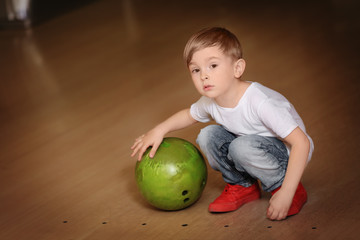 Fototapeta premium Cute child with ball in bowling club