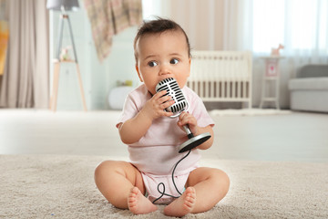 Cute little baby with microphone at home