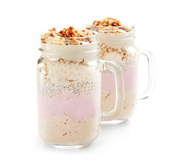 Delicious parfait with granola in jar on white background