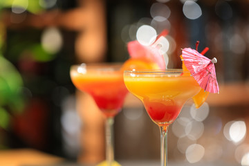 Tequila Sunrise cocktail in glass on blurred background