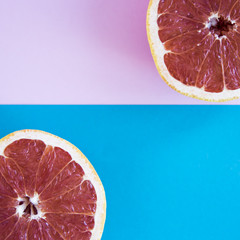 Cut in half a grapefruit on a pink and blue background