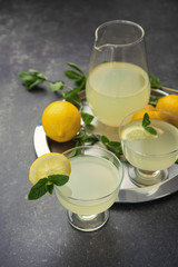 Delicious lemon juice in glasses and pitcher on tray