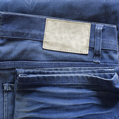 Blank grunge dirty leather label on a blue jeans