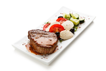 Grilled steak with mozarella and vegetables on white background
