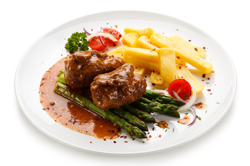 Wrapped pork chop with french fries and asparagus on white background