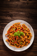 Pasta with tomato sauce on wooden table
