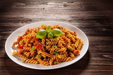 Pasta with tomato sauce on wooden table