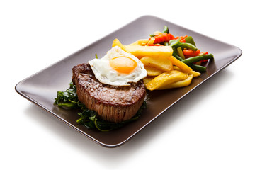 Grilled steak with french fries and fried egg