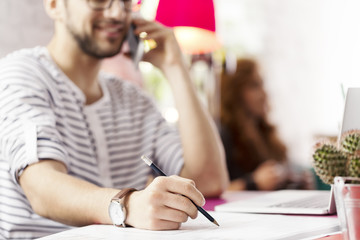 Hipster businessman taking notes
