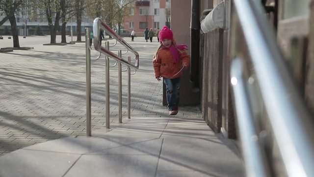 a little girl walks through the city
