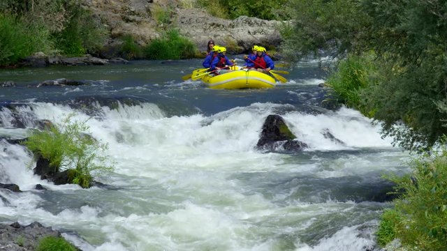 Group of people white water rafting in slow motion