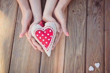 Child and mother's hands holding heart