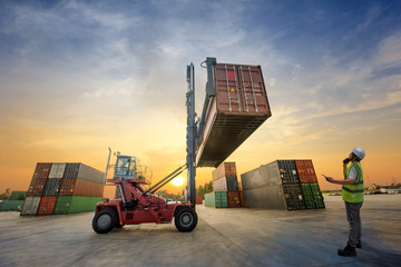 forklift handling container in yard with foreman in charge under control - obrazy, fototapety, plakaty