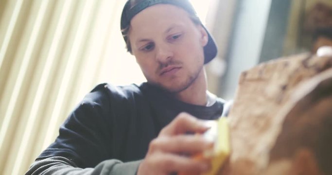 Carpenter Shaping Wood With Chisel