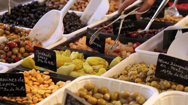 Assortment of spiced olives, vegetables and pickles on the farmers market stand in France. Regional cuisine, natural healthy food and abundance concept