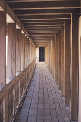 Wooden tunnel with road and door ahead
