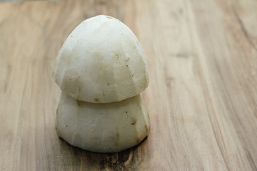 Peeled coconut, on a wooden background, close-up