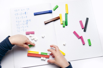 Open exercise book with colored plastic math learning tools number rods on white background....