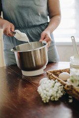 Young woman baking a cake using a mixer