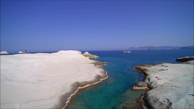 Drones backward flight over Sarakiniko on the island of Milos. Slow gliding flight recorded in UHD and optimized for the resolution of 1920x1080.
