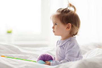 Fototapeta premium lovely little girl with toys in bed at home