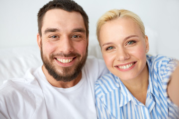 happy couple taking selfie at home