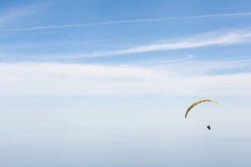 Skydiver plans against the blue sky