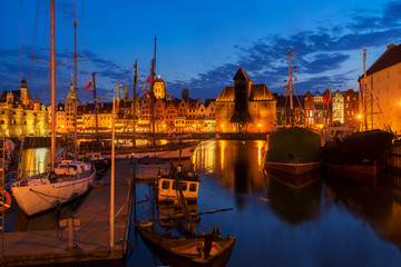 Fototapeta na wymiar Night in Gdansk - old town waterfront with ships harbor illuminated in night, Gdansk, Poland