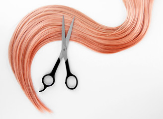 Long blond hair and scissors isolated on white