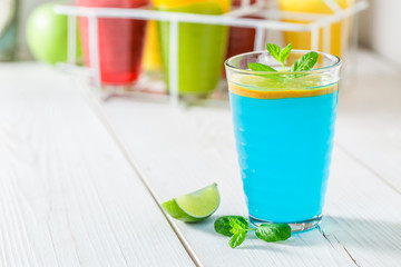 Blue cocktail with fresh fruits on white table