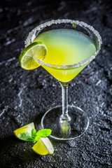 Tasty classic Margarita with fresh lime on black rock