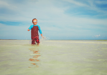 little boy enjoy play with water on beach