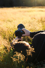 Nature photographer taking photo of wildlife. Man in the grass with a camera
