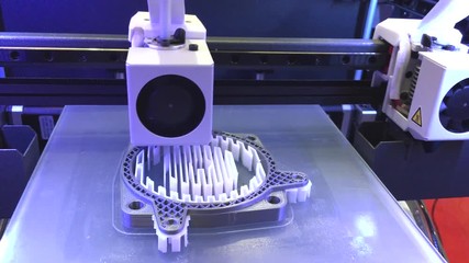 3D Printing Machine printing a piece of plastic. Working 3d printer.