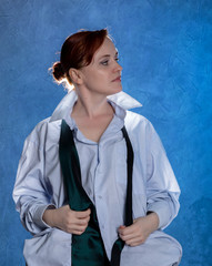 Beautiful sensual businesswoman in men's shirt and tie on a blue background