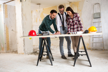 Three  architects checking blueprint