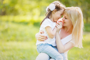 Cute young daughter on a piggy back ride with her mother.