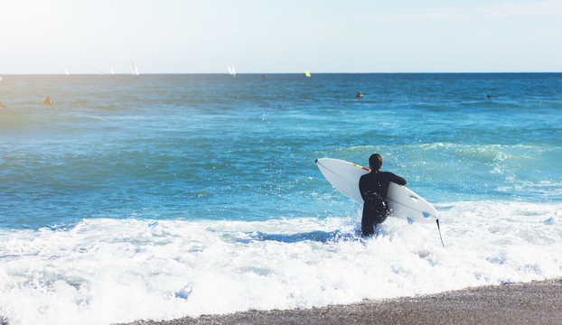 Surfer girl holding surfboard on background sea scape, sand beach coastline. Panorama horizon perspective view ocean, sunlight. Travel summer sport concept, backdrop sunny waves seascape, mock up