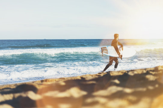 Surfer man holding surfboard on background sea scape, sand beach coastline. Panorama horizon perspective view ocean, sunlight. Travel summer sport concept, backdrop sunny waves seascape, mock up