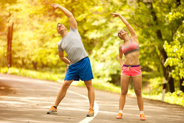 young smiling happy fitness couple in forest