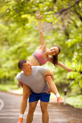 young smiling happy fitness couple in forest
